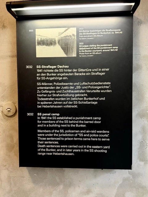 Fotografien ehemaliger Dachau-Häftlinge an einer Erinnerungswand
